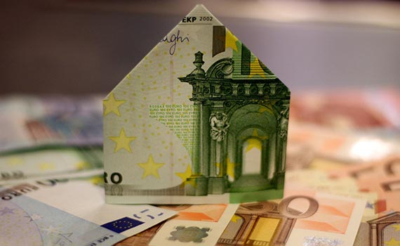 Billet de 100 euros plié en forme de maison pour représenter la trésorerie obtenue grâce à la vente à réméré